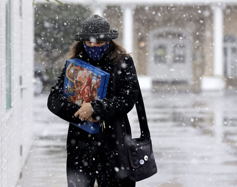 Denise Dutton walks in the snow while shopping Wednesday in Tulsa, Okla.