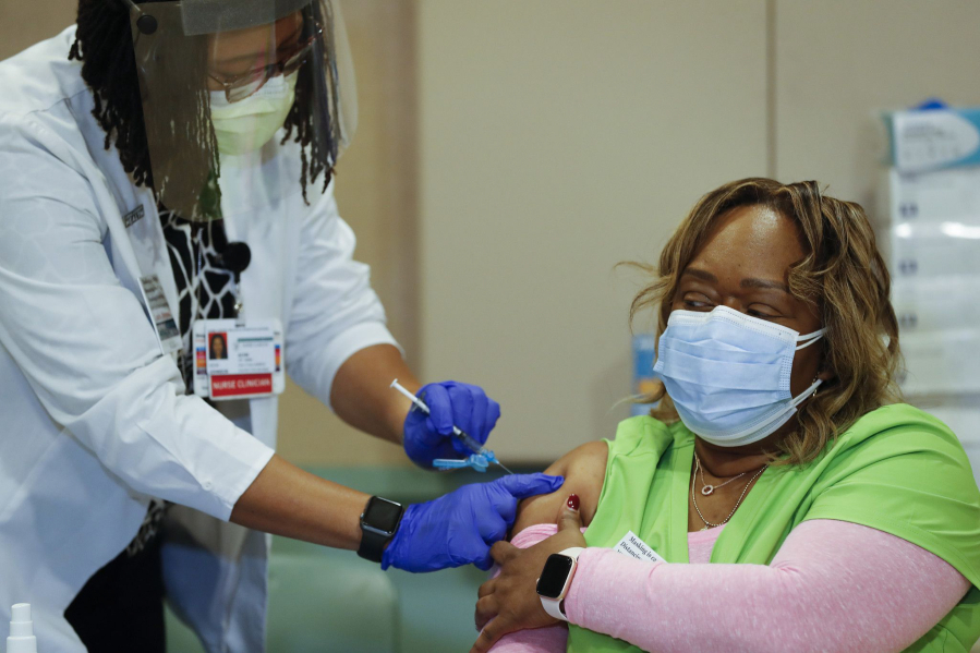 Nurse clinician Vicki Johnson gives ER nurse Tracy Everett her second COVID-19 vaccine at Stroger Hospital in Chicago on Jan. 7, 2021. (Jose M.