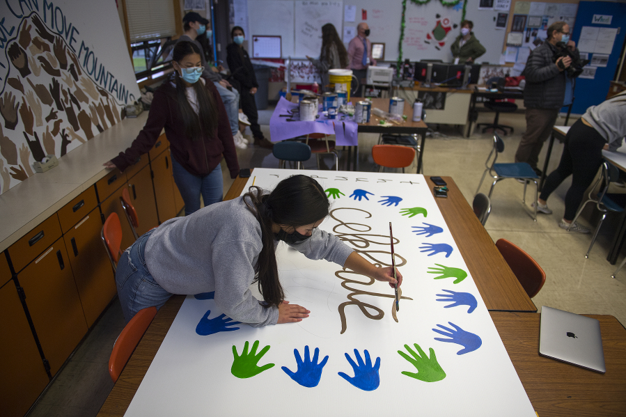 Mountain View High School junior Makaila Inoncilo, 16, foreground, joins fellow leadership student Nancy Flores, 16, also a junior, while creating a mural with a positive message. The murals created by the leadership students will be displayed on campus.