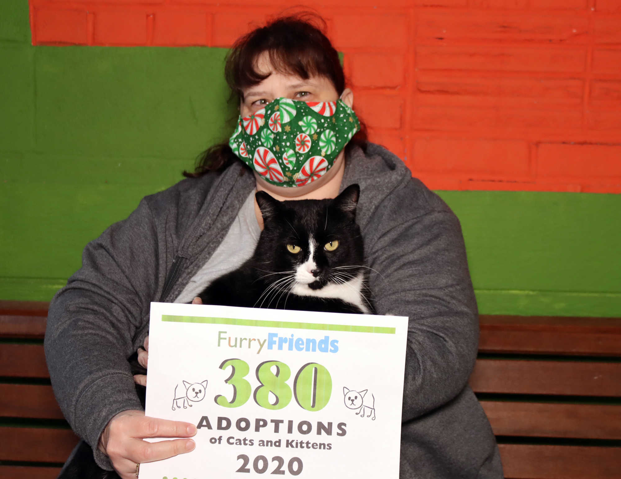 MINNEHAHA: Julie Goldbeck holds cat Milo with a sign marking a historic number of adoptions during 2020 for Furry Friends.