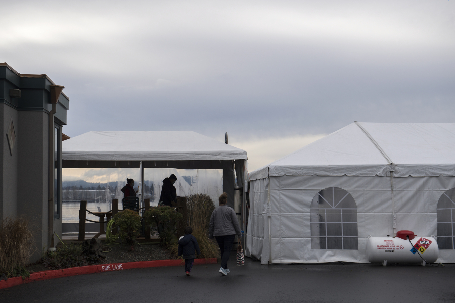 Customers make their way into a dining tent along the exterior of Beaches Restaurant &amp; Bar on Thursday. Indoor dining has been banned in Washington since November due to a spike in COVID-19 cases.