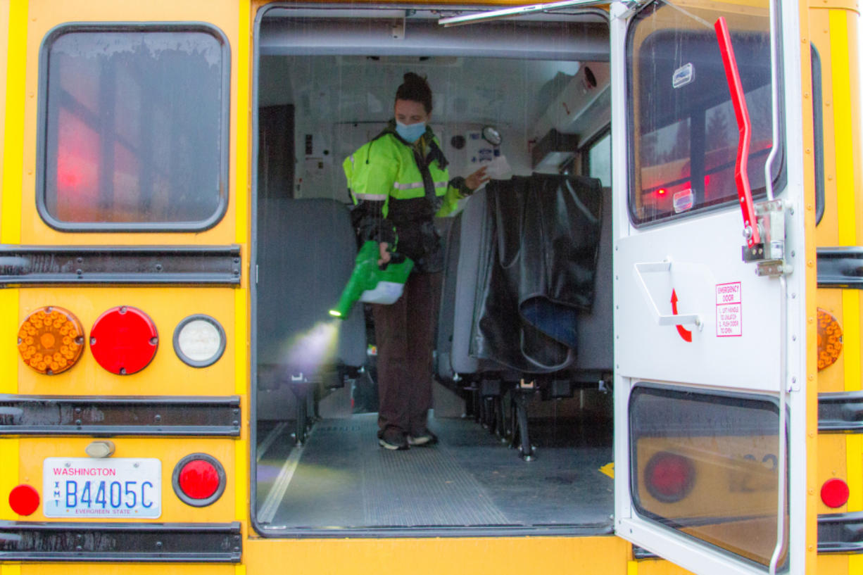WOODLAND: Mary Martin, a KWRL driver, uses an electrostatic sprayer to clean buses.