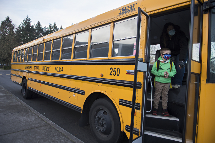 First-grader Kolby Schave, 6, prepares to depart the school bus while arriving for hybrid classes at Crestline Elementary School on Tuesday morning.