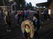 First-grader Mia Pierce, 6, bundles up in a coat before attending hybrid classes at Crestline Elementary School on Tuesday morning. Evergreen Public Schools, plus other area school districts, welcomed more students into classrooms for hybrid learning -- the first time they&#039;ve been in a classroom since COVID-19 shut schools down in March. Hockinson and Washougal welcomed first-, second- and third-graders.