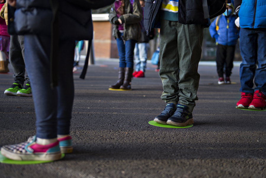 Kindergartners and first-graders at Crestline Elementary School line up on their spot while social distancing before class.