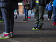 Kindergartners and first-graders at Crestline Elementary School line up on their spot while social distancing before class on Tuesday morning, January 19, 2021.