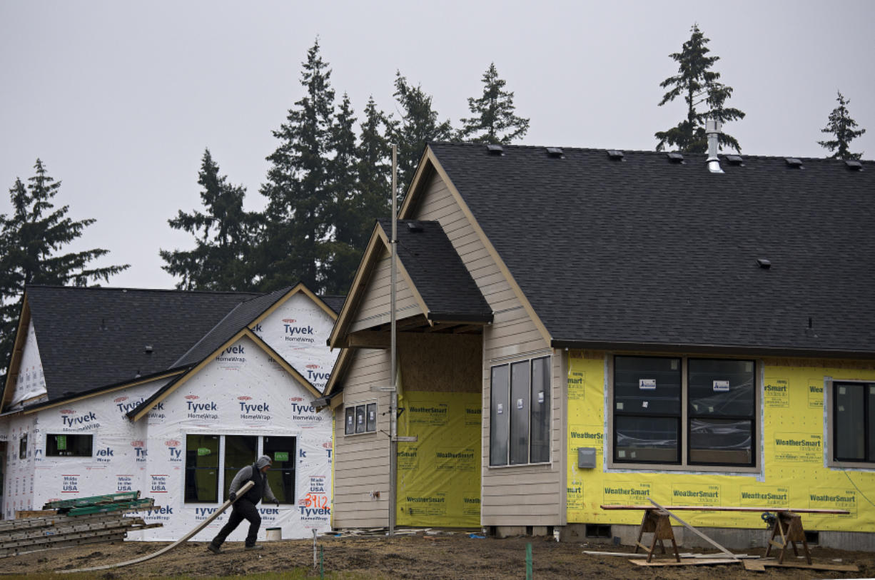 A worker lends a hand at a house under construction in the Felida Overlook neighborhood Wednesday morning. A set of energy code updates is set to take effect Feb. 1, and builders have expressed concern that the new rules could drive up construction costs at a time when the COVID-19 pandemic has already pushed up home prices.