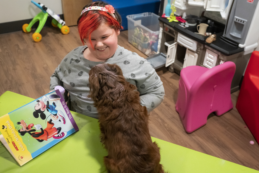 Aurora, the daughter of a resident at the Homestead Share House, and her dog Koda play in a toy room at the newly renovated shelter  on Wednesday afternoon.