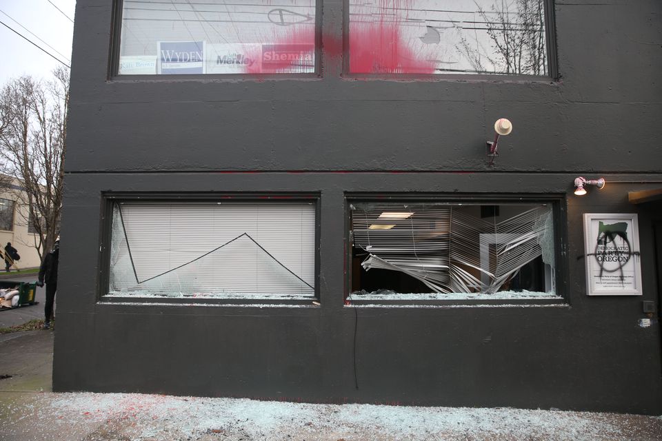 Protesters tag and smash windows at the Democratic Party of Oregon headquarters during the J20 march in Southeast Portland.