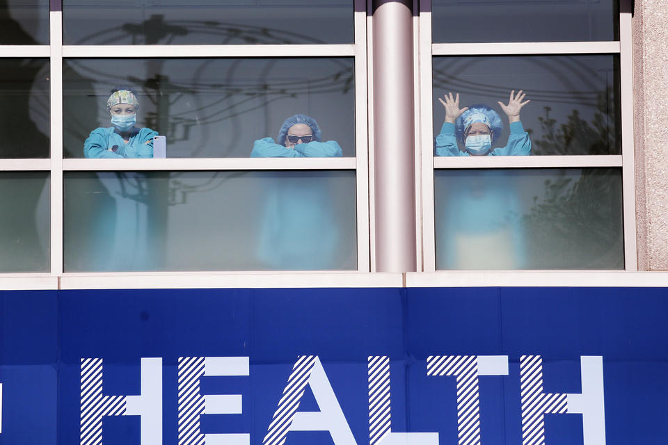 Swedish Medical Center health care workers battling the coronavirus outbreak look on from inside the hospital as first responders gathered outside in support of them in Seattle in April. The COVID-19 pandemic was Washington state's top story for 2020.