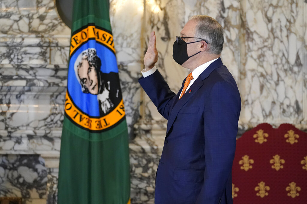 Washington Gov. Jay Inslee takes the oath of office for his third term as Governor, Wednesday, Jan. 13, 2021, during a ceremony at the Capitol in Olympia, Wash. (AP Photo/Ted S.