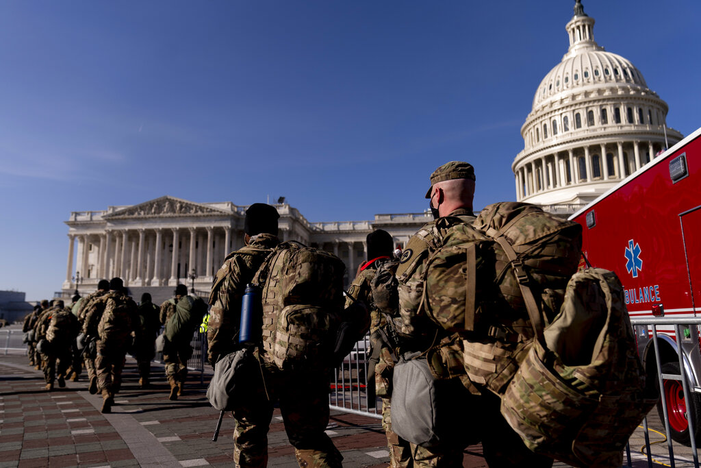 Members of the National Guard walk past the Dome of the Capitol Building on Capitol Hill in Washington, Thursday, Jan. 14, 2021.