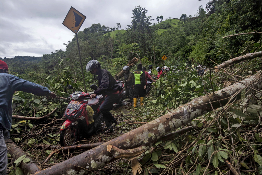 Motorists make their way through a road affected by an earthquake-triggered landslide near Mamuju, West Sulawesi, Indonesia, Saturday, Jan. 16, 2021. Damaged roads and bridges, power blackouts and lack of heavy equipment on Saturday hampered Indonesia&#039;s rescuers after a strong and shallow earthquake left a number of people dead and injured on Sulawesi island.