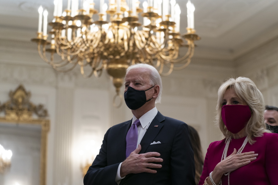 President Joe Biden, accompanied by first lady Jill Biden, places his hand over his heart during a performance of the national anthem, during a virtual Presidential Inaugural Prayer Service in the State Dinning Room of the White House, Thursday, Jan. 21, 2021, in Washington.