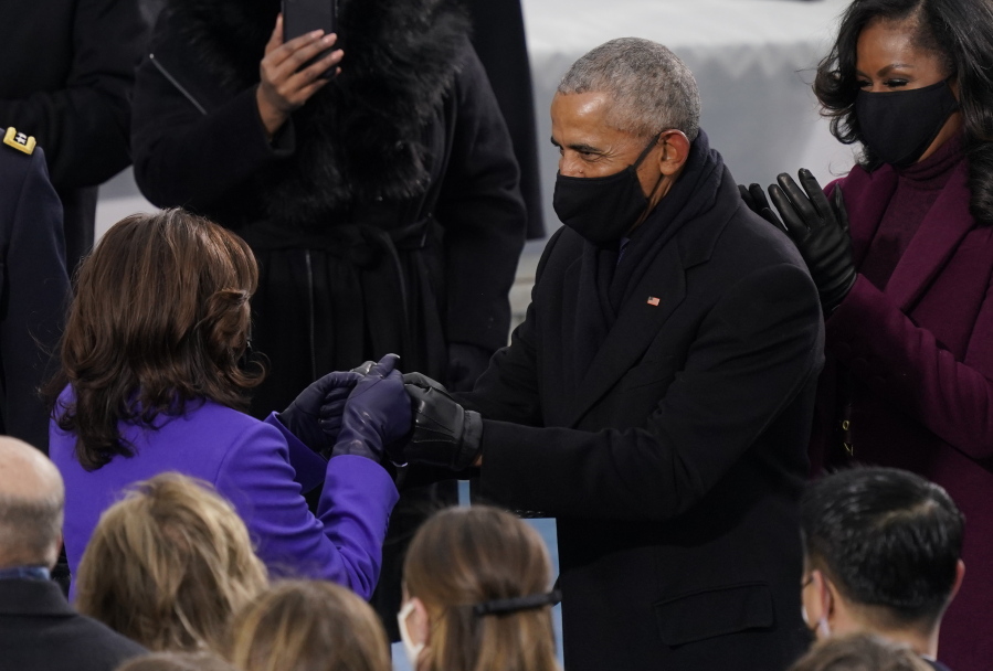 Former President Barack Obama and Vice President-elect Kamala Harris fist bump as Harris arrives for the 59th Presidential Inauguration at the U.S. Capitol in Washington, Wednesday, Jan. 20, 2021. At right is Michelle Obama.