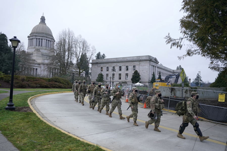 Washington National Guard members walk in formation away from the Legislative Building, Wednesday, Jan. 20, 2021, at the Capitol in Olympia, Wash. Members of the Guard and Washington State Patrol troopers have been in place all week on the campus providing security against possible protests connected with the inauguration of President Joe Biden and the departure of former President Donald Trump in Washington, D.C. (AP Photo/Ted S.