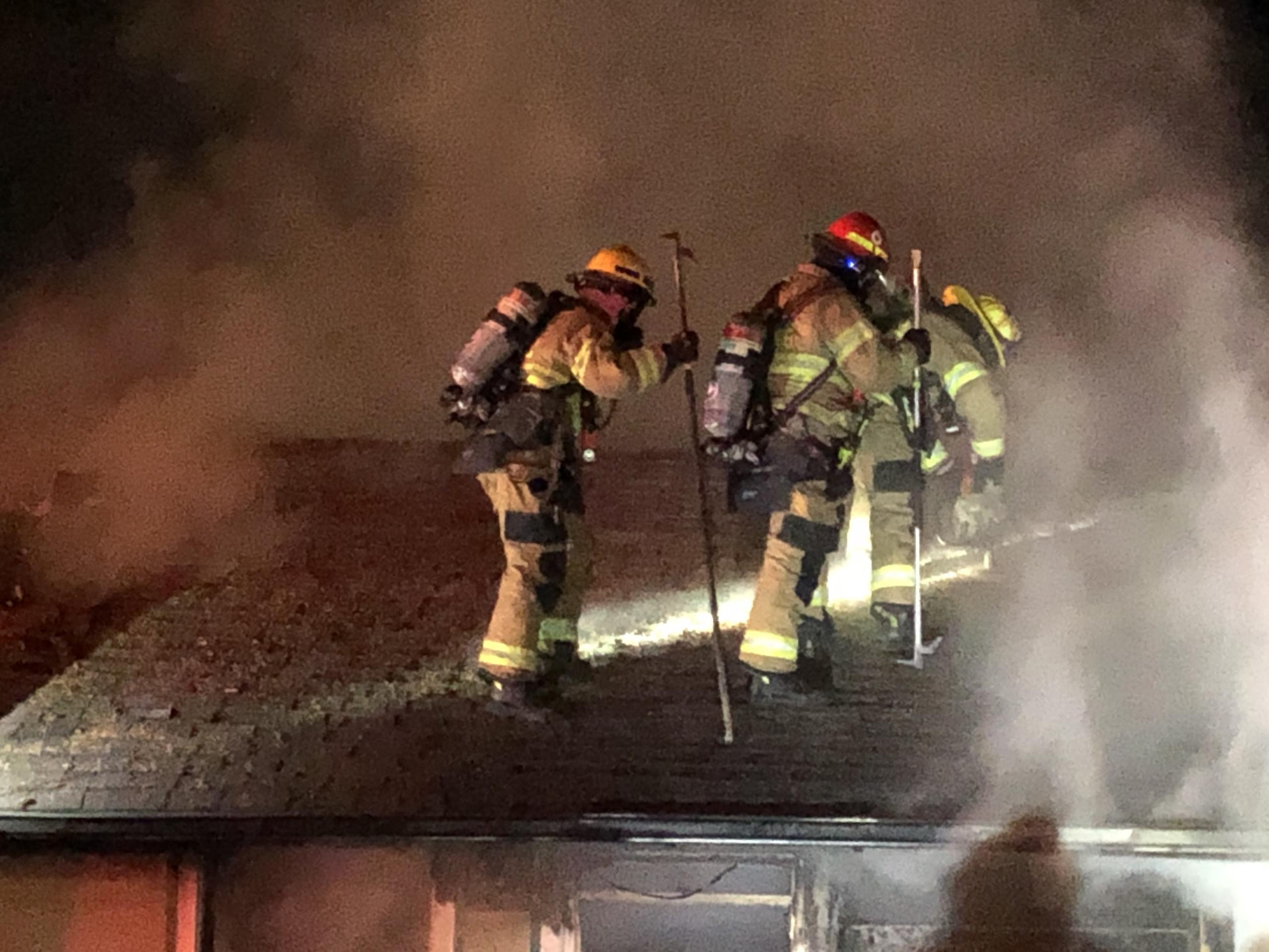 Firefighters make a "trench-cut" in the roof to stop the spread of fire in the attic.