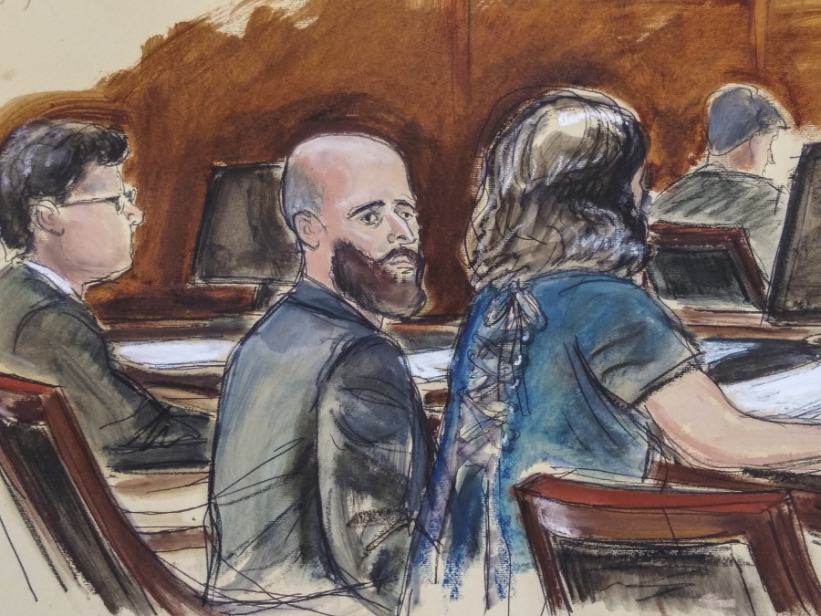 In this Wednesday March 4, 2020 courtroom sketch Joshua Schulte, center, is seated at the defense table flanked by his attorneys during jury deliberations in New York. Joshua Schulte, a former CIA software engineer charged with leaking government secrets to WikiLeaks says it&#039;s cruel and unusual punishment that he&#039;s awaiting trial in solitary confinement, housed in a vermin-infested cell of a jail unit where inmates are treated like &quot;caged animals.&quot; In court papers Tuesday, Jan.