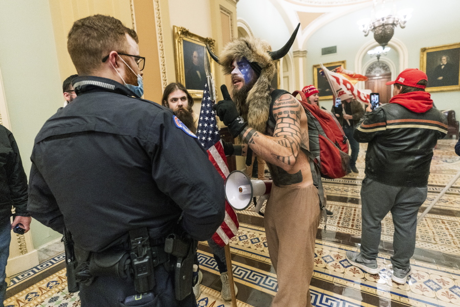 FILE - In this Jan. 6, 2021, file photo supporters of President Donald Trump are confronted by U.S. Capitol Police officers outside the Senate Chamber inside the Capitol in Washington. An Arizona man seen in photos and video of the mob wearing a fur hat with horns was also charged Saturday in Wednesday&#039;s chaos. Jacob Anthony Chansley, who also goes by the name Jake Angeli, was taken into custody Saturday, Jan. 9.