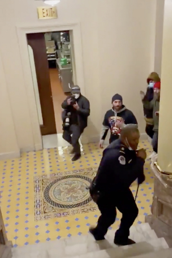 In this image made from video and provided by HuffPost, Capitol Police Officer Eugene Goodman calls for backup as an angry mob gives chase inside the U.S. Capitol in Washington on Jan. 6, 2021. One bright spot in all the chaos and anger from the mob siege at the U.S. Capitol was Goodman confronting a mob and retreating, risking his life to perhaps save the U.S. Senate.