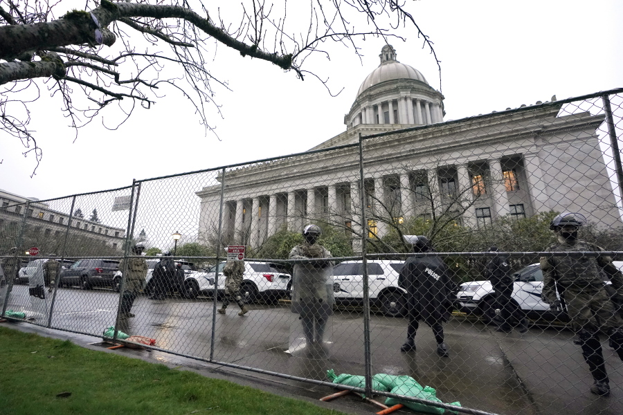 Members of the Washington National Guard stand near a fence surrounding the Capitol in anticipation of protests Monday, Jan. 11, 2021, in Olympia, Wash. State capitols across the country are under heightened security after the siege of the U.S. Capitol last week. (AP Photo/Ted S.