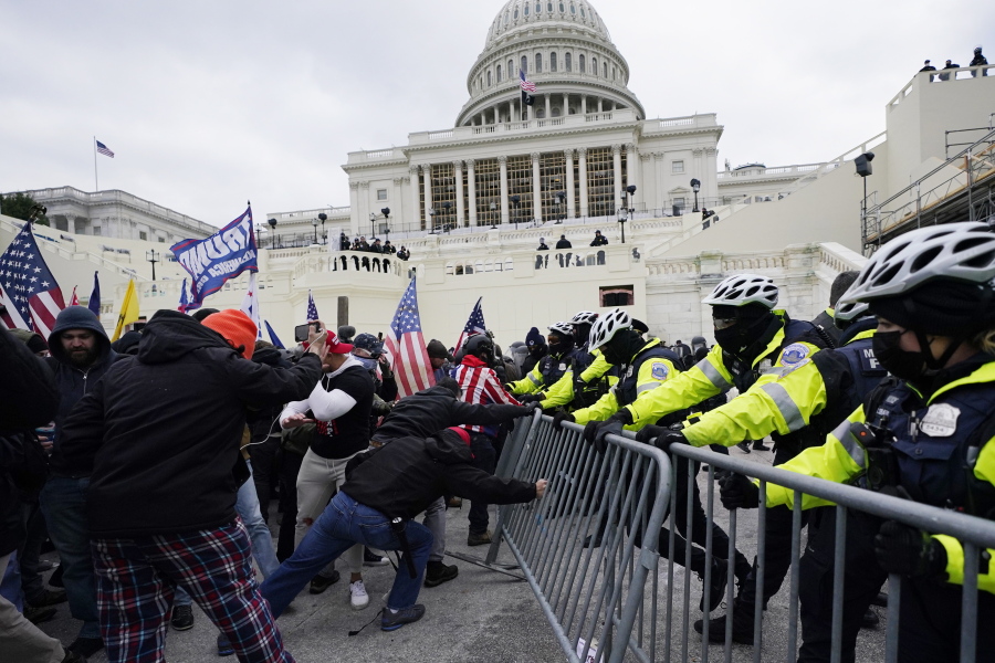 FILE - In this Wednesday, Jan. 6, 2021 file photo, Trump supporters try to break through a police barrier at the Capitol in Washington.  Right-wing extremism has previously mostly played out in isolated pockets of America or in smaller cities. In contrast, the deadly attack by rioters on the U.S. Capitol targeted the very heart of government. It brought together members of disparate groups, creating the opportunity for extremists to establish links with each other.