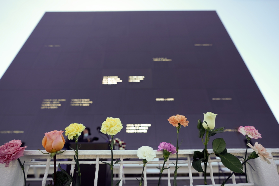 Flowers line the railing placed their by visitors at the Space Mirror Memorial during a ceremony to honor fallen astronauts at the Kennedy Space Center Visitors Complex, Thursday, Jan. 28, 2021, in Cape Canaveral, Fla. The memorial displays the names of astronauts that lost their lives furthering the cause of space exploration.