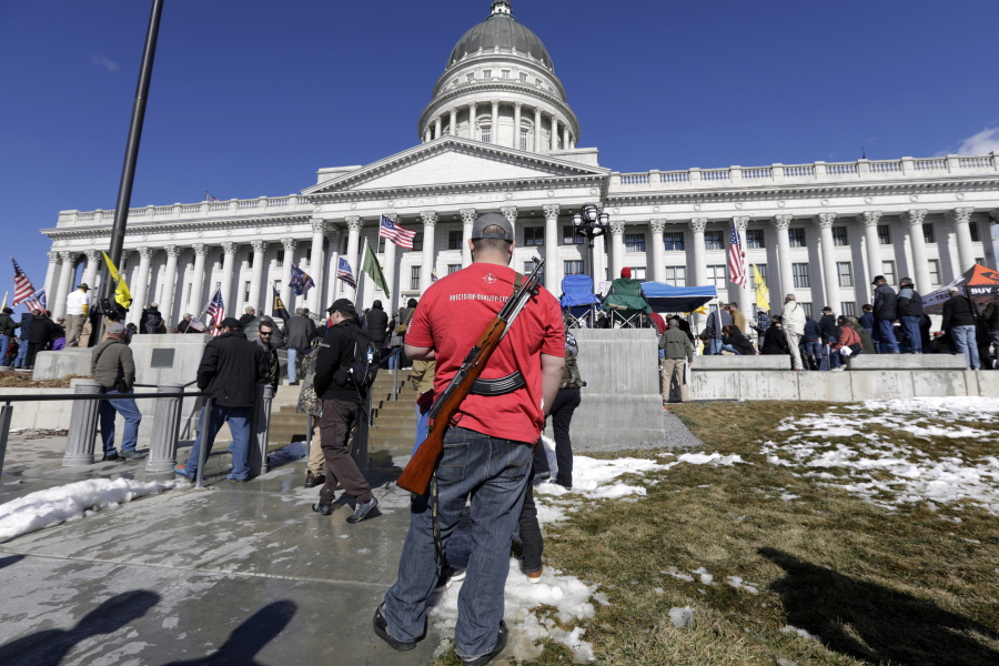 FILE - A man carries his weapon during a second amendment gun rally at Utah State Capitol on Feb. 8, 2020, in Salt Lake City. Utah is one of several more states weighing proposals this year that would allow people to carry concealed guns without having to get a permit, a trend supporters say bolsters Second Amendment rights but is alarming to gun-control advocates.