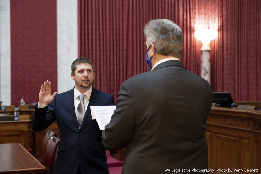 West Virginia House of Delegates member Derrick Evans, left, is given the oath of office Dec. 14, 2020, in the House chamber at the state Capitol in Charleston, W.Va. Evans recorded video of himself and fellow supporters of President Donald Trump storming the U.S. Capitol in Washington, D.C., on Wednesday, Jan. 6, 2021 prompting calls for his resignation and thousands of signatures on an online petition advocating his removal.