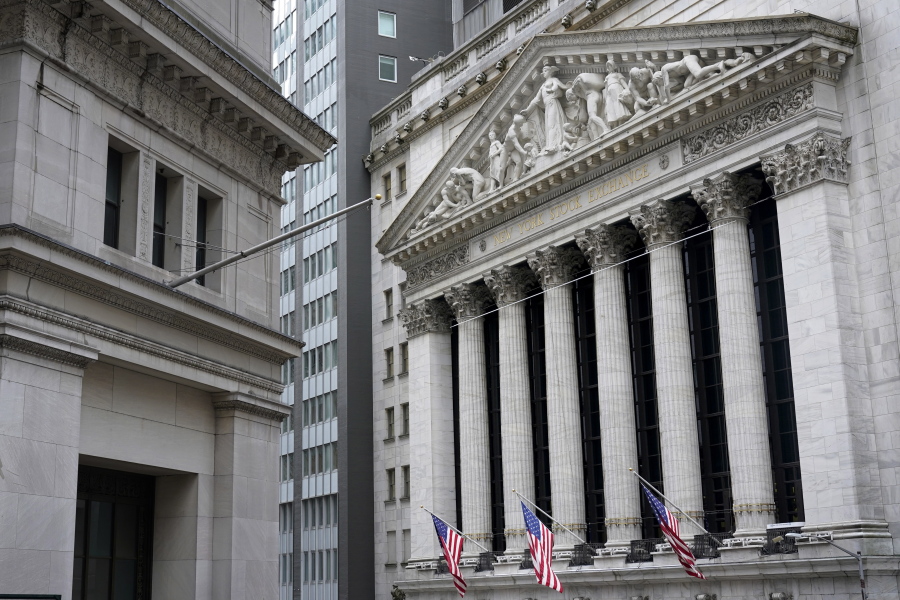 FILE - This Monday, Nov. 23, 2020 file photo shows the New York Stock Exchange, right, in New York. Stocks are churning close to the breakeven line in the early going on Wall Street Thursday, Jan. 21, 2021,  as traders increase their focus on company earnings reports.