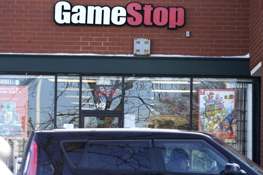 A vehicle passes in front of a GameStop store in Vernon Hills, Ill., on Thursday. The online trading platform Robinhood is moving to restrict trading in GameStop and other stocks that have soared recently due to rabid buying by smaller investors. (Nam Y.