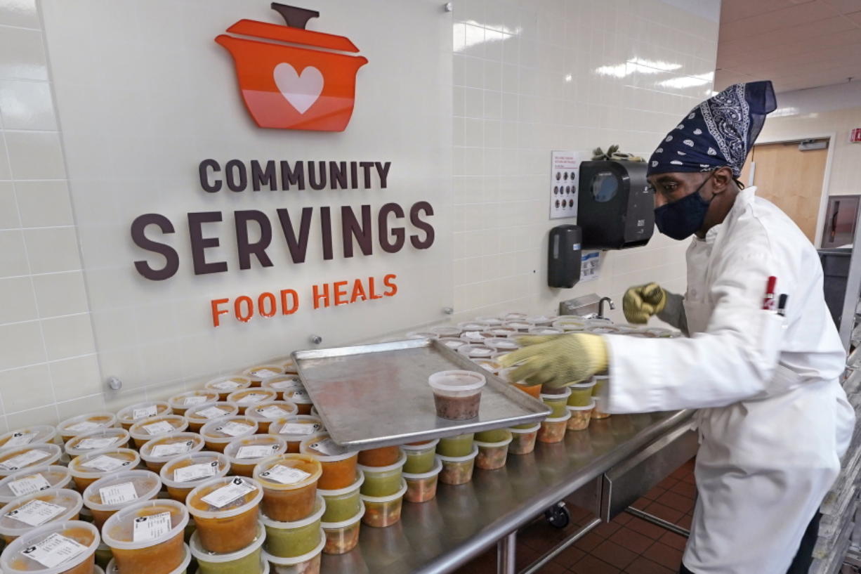 Chef Jermaine Wall stacks containers of soups at Community Servings, which prepares and delivers scratch-made, medically tailored meals to individuals &amp; families living with critical &amp; chronic illnesses, Tuesday, Jan. 12, 2021, in the Jamaica Plain neighborhood of Boston. Food is a growing focus for insurers as they look to improve the health of the people they cover and cut costs. Insurers first started covering Community Servings meals about five years ago, and CEO David Waters says they now cover close to 40%.