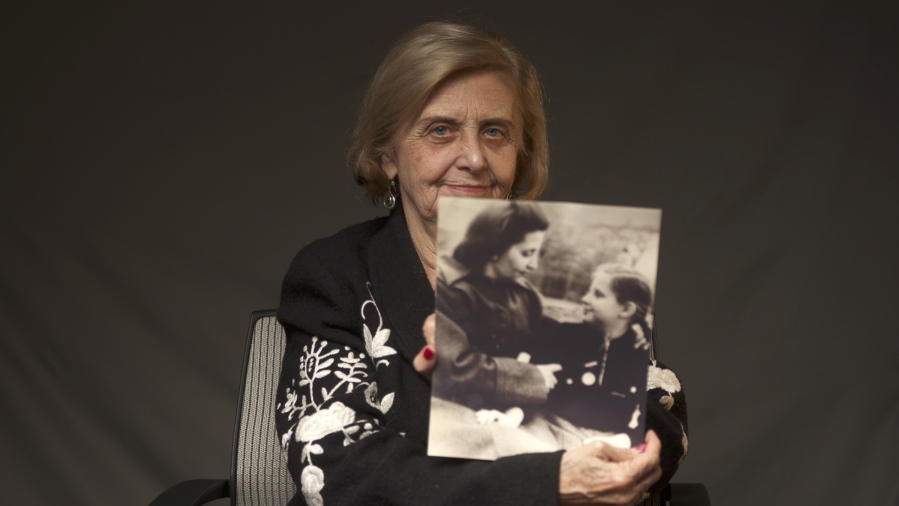 This photo provide by the World Jewish Congress, Tova Friedman, an 82-year-old Polish-born Holocaust survivor holding a photograph of herself as a child with her mother, who also survived the Nazi death camp Auschwitz, in New York, Friday, Dec.13, 2019.  Friedman is delivering a warning against rising hatred in the world during an online commemoration on Wednesday, the 76th anniversary of the liberation of Auschwitz by Soviet troops at end of World War II. The commemorations for the victims of the Holocaust at the International Holocaust Remembrance Day, marking the liberation of Auschwitz-Birkenau on Jan. 27, 1945, will be mostly online in 2021 due to the coronavirus pandemic.