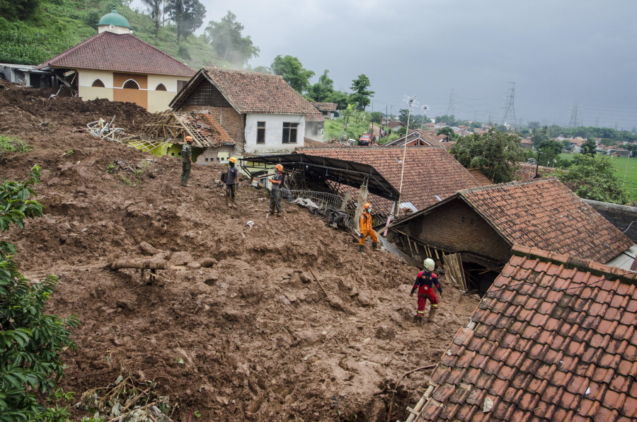 Rescuers search for victims at a village hit by Sunday&#039;s landslides in Sumedang, West Java, Indonesia, Monday, Jan. 11, 2021. Landslides triggered by heavy rain in the village left at a number of people died and injured, officials said.