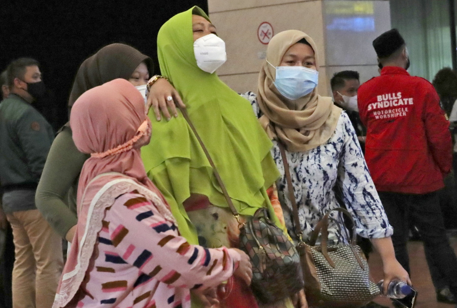 Relatives of passengers arrive at a crisis center set up following a report that a Sriwijaya Air passenger jet has lost contact with air traffic controllers shortly after take off, at Soekarno-Hatta International Airport in Tangerang, Indonesia,Saturday, Jan. 9, 2021. The Boeing 737-500 took off from Jakarta with 56 passengers and six crew members onboard, and lost contact with the control tower a few moments later.
