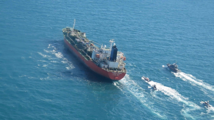 In this photo released Monday, Jan. 4, 2021, by Tasnim News Agency, a seized South Korean-flagged tanker is escorted by Iranian Revolutionary Guard boats on the Persian Gulf. Iranian state television acknowledged that Tehran seized the oil tanker in the Strait of Hormuz. The report on Monday alleged the MT Hankuk Chemi had been stopped by Iranian authorities over alleged &quot;oil pollution&quot; in the Persian Gulf and the strait.