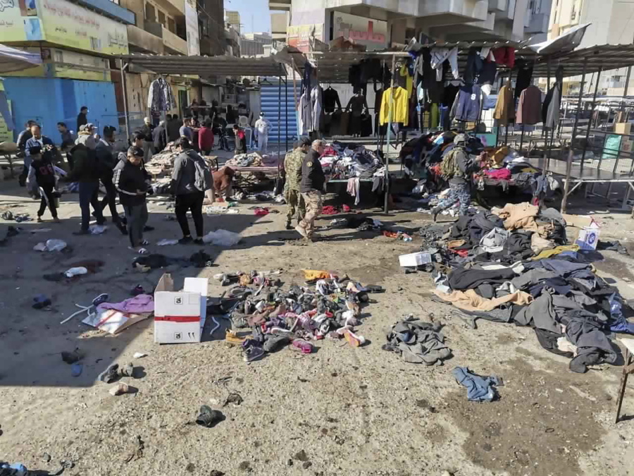 People and security forces gather at the site of a deadly bomb attack in a market selling used clothes, Iraq, Thursday, Jan. 21, 2021. Twin suicide bombings hit Iraq&#039;s capital Thursday killing and wounding civilians, police and state TV said.