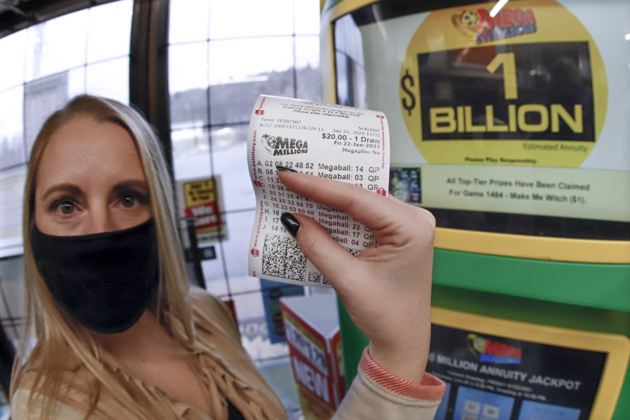 A patron, who did not want to give her name, shows the ticket she had just purchased for the Mega Millions lottery drawing at the lottery ticket vending kiosk in a Smoker Friendly store, Friday, Jan. 22, 2021, in Cranberry Township, Pa. The jackpot for the Mega Millions lottery game has grown to $1 billion ahead of Friday night&#039;s drawing after more than four months without a winner.