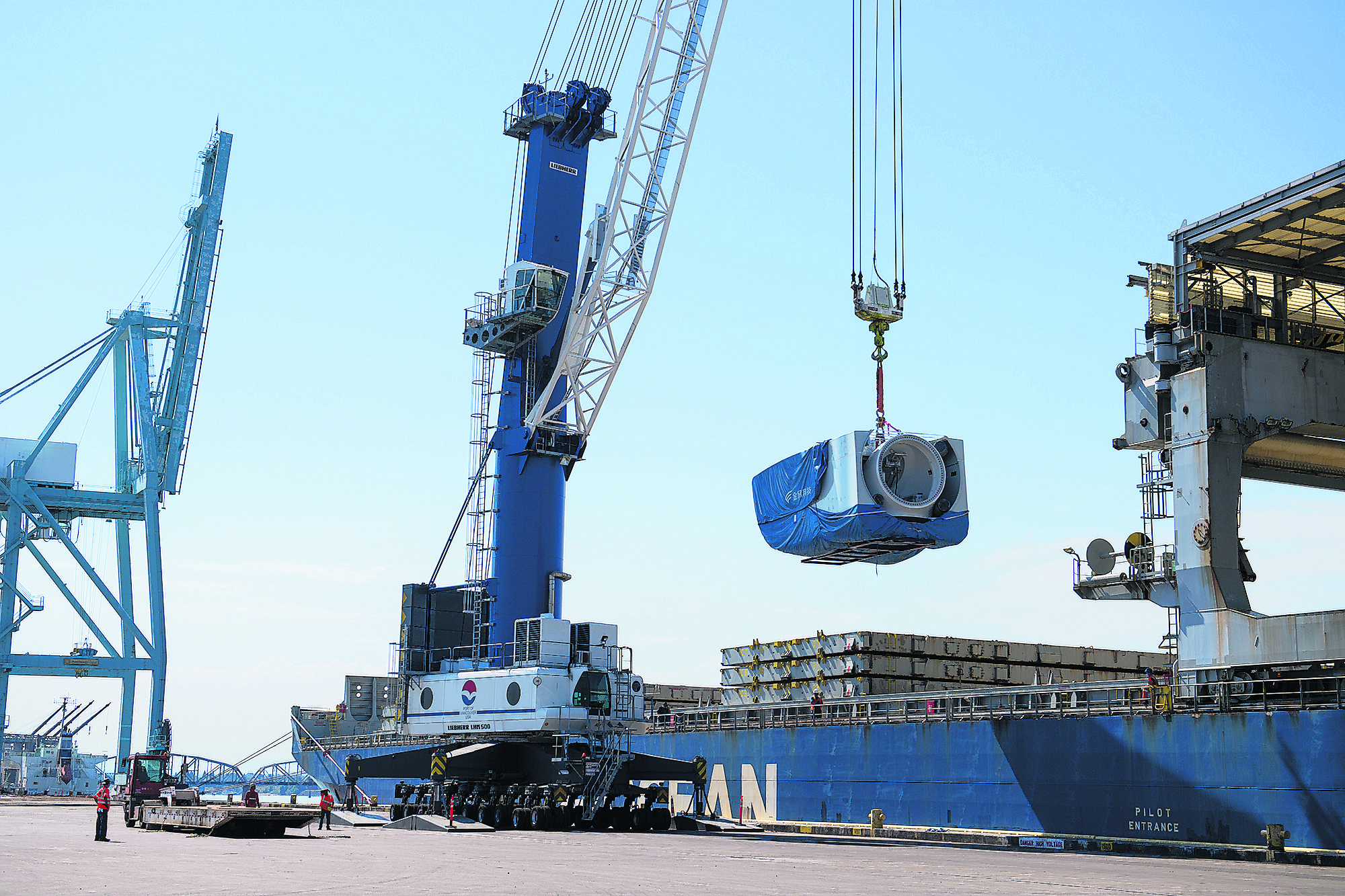 Crews unload a nacelle, the piece where the blades and turbine meet, from a ship at the Port of Vancouver on Monday morning, July 27, 2020.