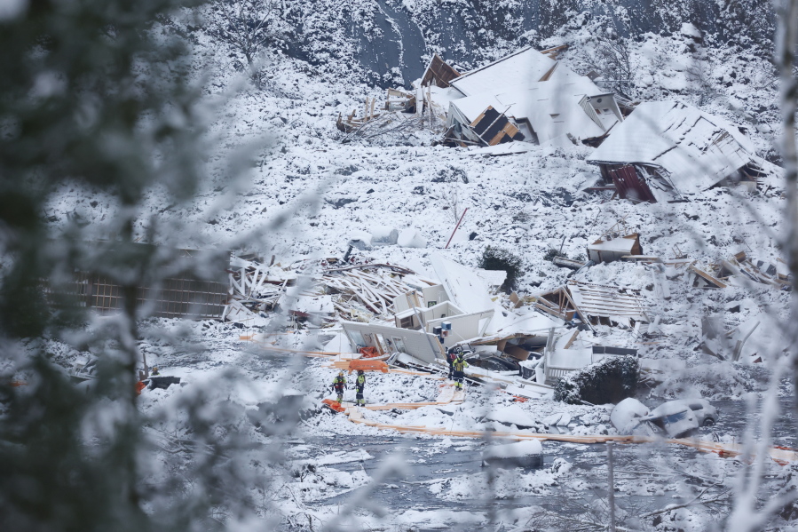 Rescue crews work in the area at Ask in Gjerdrum, Saturday Jan. 2, 2021, after a massive landslide smashed into a residential area near the Norwegian capital on Wednesday. The landslide cut across a road through Ask, leaving a deep ravine that cars could not pass.