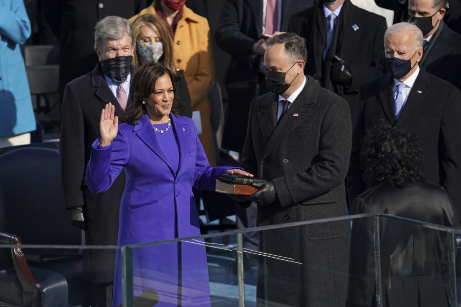 FILE - Kamala Harris is sworn in as vice president by Supreme Court Justice Sonia Sotomayor as her husband Doug Emhoff holds the Bible during the 59th Presidential Inauguration at the U.S. Capitol in Washington, Wednesday, Jan. 20, 2021.   On Friday, Jan. 22, The Associated Press reported on stories circulating online incorrectly claiming Kamala Harris put her hand on a purse instead of a Bible during her swearing in.