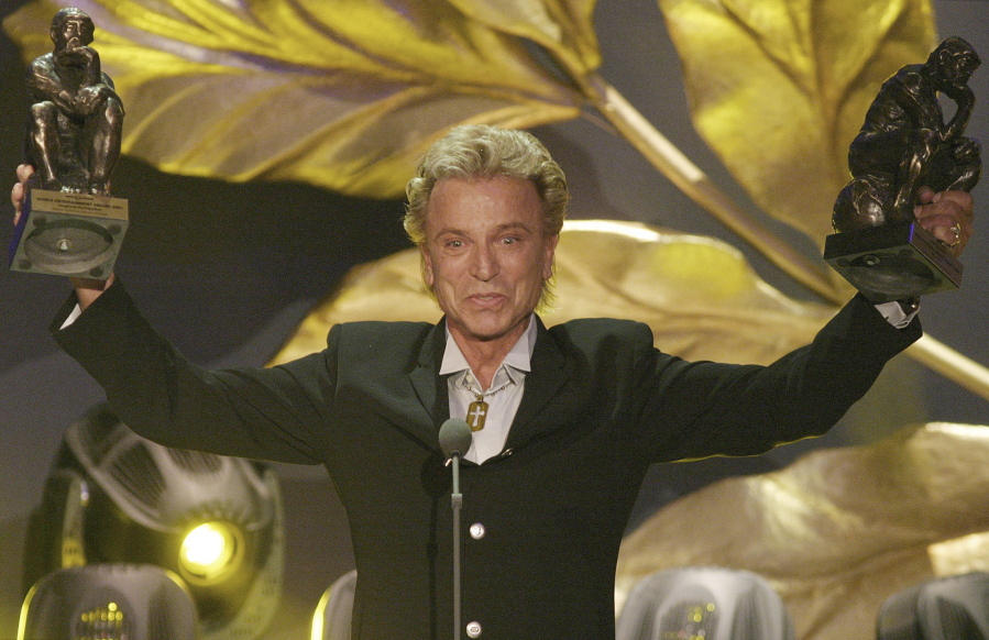 FILE - German illusionist Siegfried Fischbacher of the duo &quot; Siegfried &amp; Roy&quot; holds their trophies after receiving the World Entertainment Award at the World Award 2003 ceremony in Hamburg, northern Germany, on Oct.22, 2003. German news agency dpa is reporting that  Fischbacher, the surviving member of duo Siegfried &amp; Roy has died in Las Vegas at age 81. The news agency said Thursday that Fischbacher&#039;s sister, a nun who lives in Munich, confirmed his death of cancer.