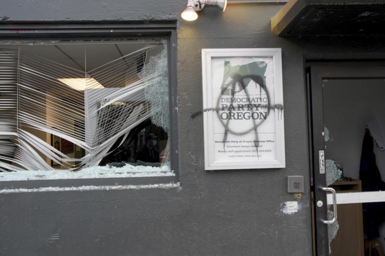 Protesters tag and smash windows at the Democratic Party of Oregon headquarters during the J20 March, Wednesday, Jan. 20, 2021, in Southeast Portland. A group of protesters carrying anti-President Joe Biden and anti-police signs marched in the streets and damaged the headquarters of the Democratic Party of Oregon.