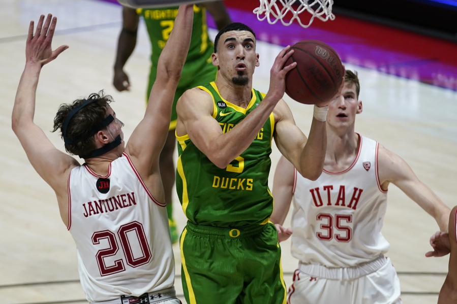 Oregon guard Chris Duarte, center, goes to the basket as Utah&#039;s Mikael Jantunen (20) and Branden Carlson (35) defend in the first half during an NCAA college basketball game Saturday, Jan. 9, 2021, in Salt Lake City.