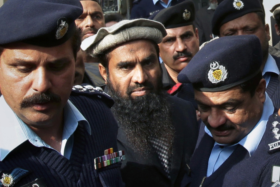 FILE - In this Thursday, Jan. 1, 2015, file photo, Pakistani police officers escort Zaki-ur-Rehman Lakhvi, center, the main suspect of the Mumbai terror attacks in 2008, after his court appearance in Islamabad, Pakistan. Pakistan&#039;s security forces arrested Saturday, Jan. 2, 2021 an alleged leader of the militant group that was behind the bloody 2008 Mumbai attacks in India. (AP Photo/B.K.
