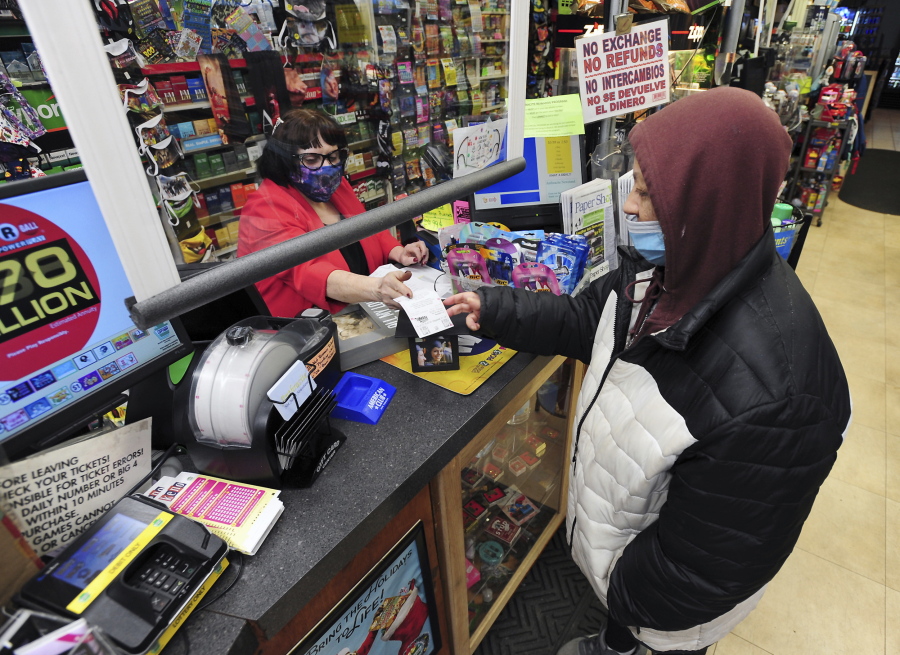 Jacqueline Donahue of Hazleton, right, buys la Mega Millions lottery ticket at the Anthracite Newsstand on Public Square, Monday, Jan. 18, 2021, in Wilkes-Barre, Pa.