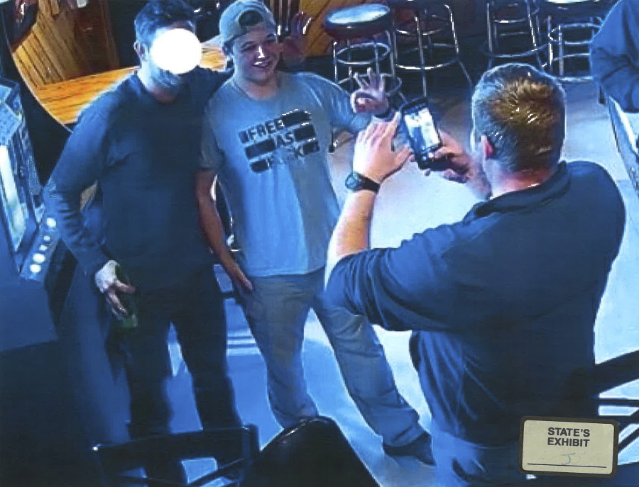 In this image from video provided by the Kenosha County District Attorney, Kyle Rittenhouse poses for a photo at Pudgy&#039;s Pub in Mount Pleasant, Wis., on Jan. 5, 2021, the day he was arraigned on charges related to the killing of two people at an August protest in Kenosha.