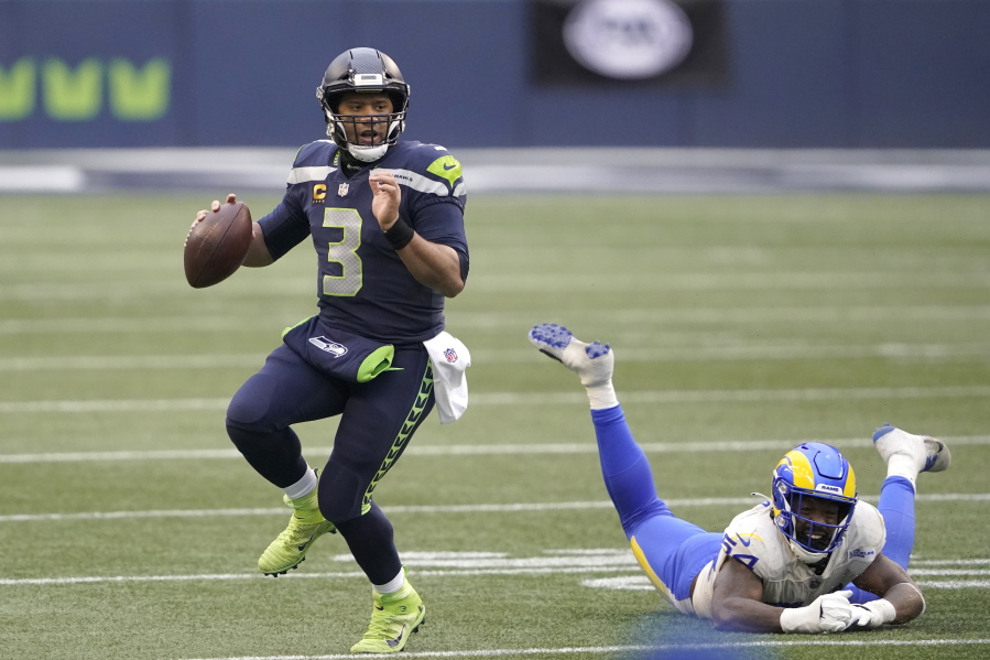 Seattle Seahawks quarterback Russell Wilson (3) scrambles away from Los Angeles Rams outside linebacker Leonard Floyd during the second half of an NFL wild-card playoff football game, Saturday, Jan. 9, 2021, in Seattle. (AP Photo/Ted S.