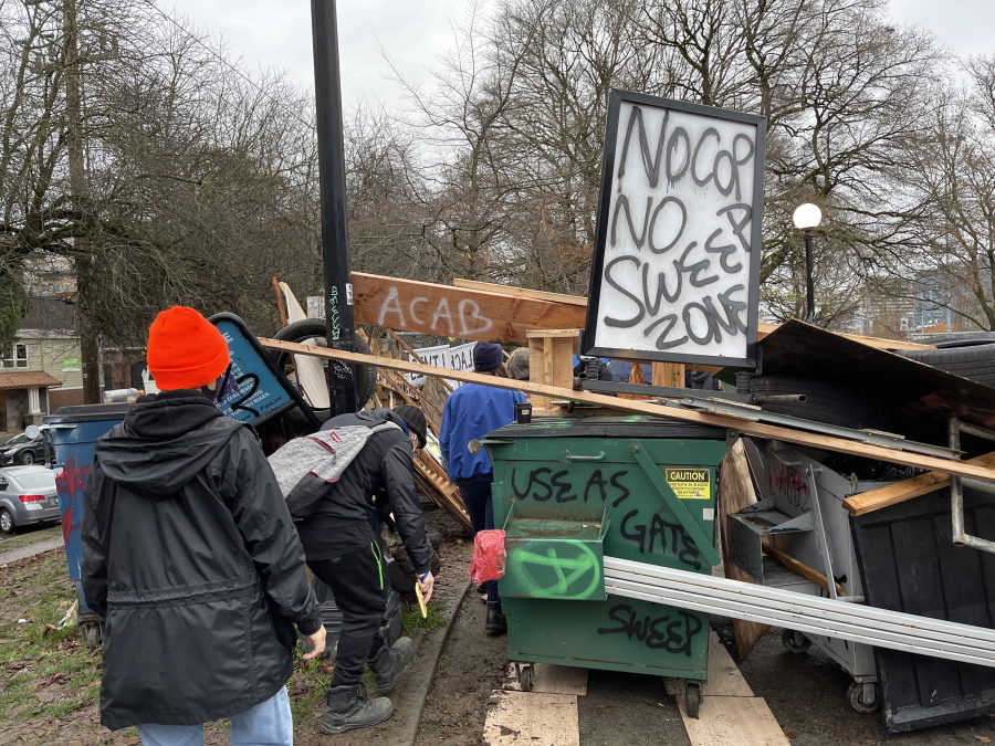 The homeless camp is completely encircled with debris and fencing blocking the City of Seattle&#039;s sweep of the camp Cal Anderson Park, Wednesday, Dec. 16, 2020, in Seattle. This is the only entrance to the area within the park.