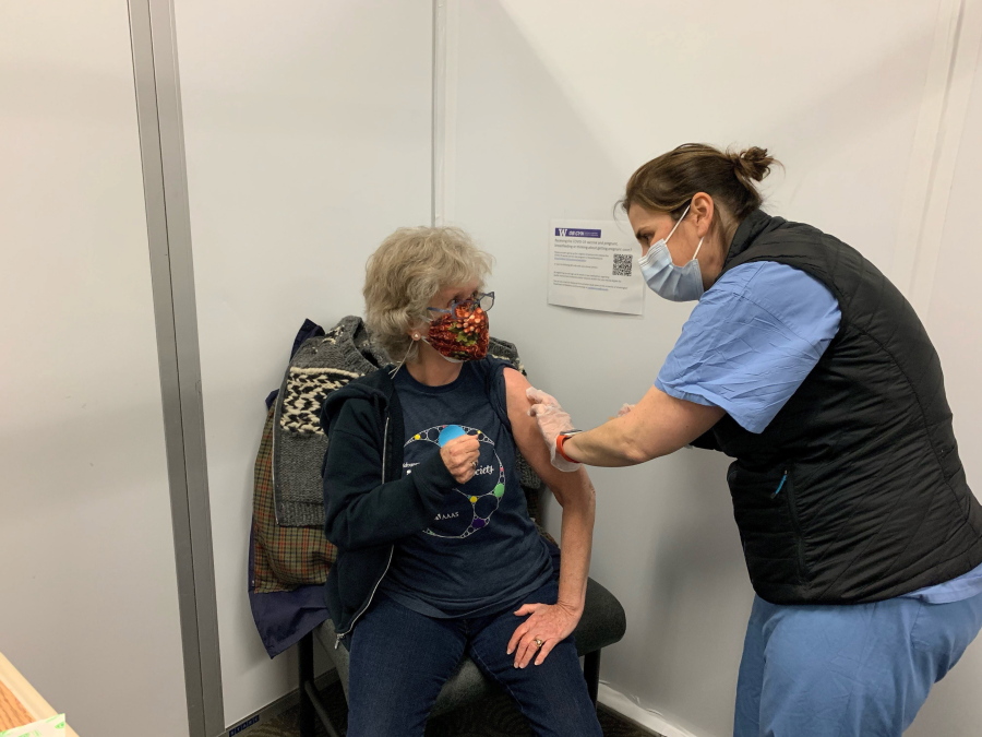 Keri Nasenbeny, associate chief nursing officer at UW Medical Center - Northwest, administers a Moderna COVID-19 vaccine to Tyson Greer, 77, early Friday, Jan. 29, 2021 in Seattle.  Hospitals rushed out COVID-19 vaccines to hundreds of people in the middle of the night after a freezer they were being stored in failed.